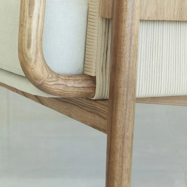 Brazo curvo de madera unido a la pata de una poltrona